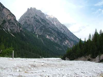 Blick vom Weg 105 zur&uuml;ck &uuml;ber das Schotterfeld, an dessem linken Rand der Ixenbach flie&szlig;t, hin&uuml;ber zum Kohlalplkofel [2543m] in der Bildmitte.