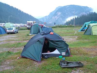 Wir haben es bis zum Zeltplatz geschafft. Der Regen hat aufgeh&ouml;rt, das Zelt ist aufgebaut. Wasserdunst steigt aus den umliegenden Bergen empor. Im Hintergrund in der Mitte ist das Bergmassiv Monte Piana mit der Stra&szlig;e zur H&uuml;tte Rif. M. Piana A. Bosi zu sehen.