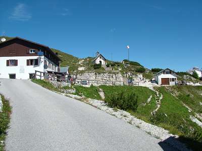 Die H&uuml;tte, ein Vorratsschuppen, eine Kapelle und eine Kanone. Vor der H&uuml;tte ist die Endstation des Jeepservices.