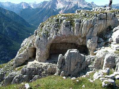 Der Berg ist teilweise unterhöhlt, hier unterhalb des Plateaus mit dem Kreuz. Man kann auch ins Tal "Val de Gotres" südlich der hohen Gaisl hinunterblicken.