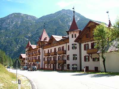 Die Vorderansicht des wundersch&ouml;nen Hotels Ploner mit dem Massiv Monte Piana im Hintergrund.