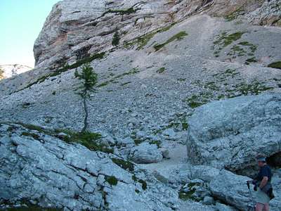 Der Weg wird steiniger und geht weiter steil bergan. Wir m&uuml;ssen dort vorn, wo sich jetzt ein roter und ein blauer Wanderer befinden, um den Felsen herumwandern.