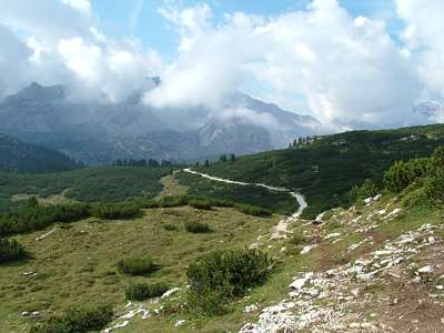 Ganz langsam geht es abw&auml;rts, die Vegetation nimmt zu. Obwohl sich das Massiv Croda Ciamin in Wolken h&uuml;llt, ist das Wetter warm und angenehm.