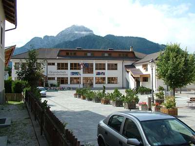 Die Grundschule mit dem Sarlkofel und dem Kasamutz im Hintergrund.