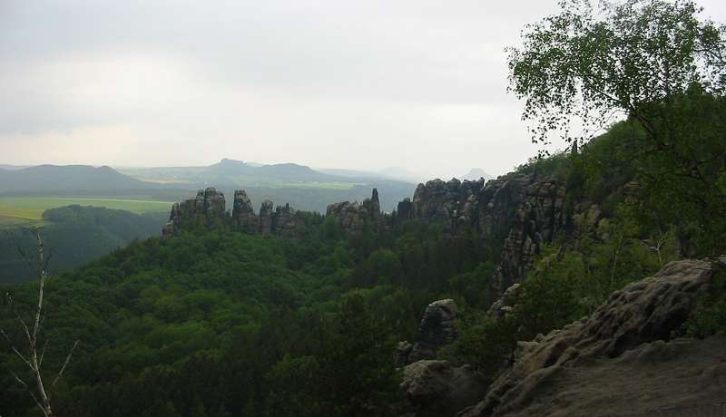 Die Aussicht vom Gratweg aus in Richtung Nord-West mit dem Schrammsteinmassiv, dabei das Gro&szlig;e Schrammtor. In der Ferne sind die Festung K&ouml;nigstein und der Lilienstein zu erkennen.