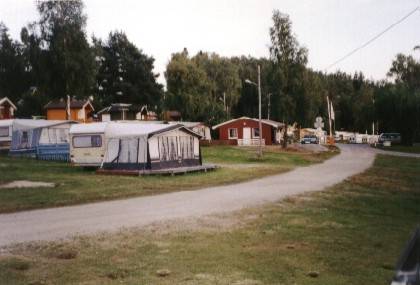 Blick vom Zelt zum Zeltplatzeingang mit Rezeption und Schranke.