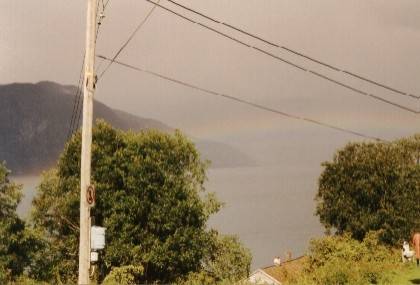 Auf der anderen Seite des Fjords regnet es stark, bei uns lugt die Sonne durch die Wolken, eine nat&uuml;rliche Br&uuml;cke scheint Manheller mit Fodnes zu verbinden.