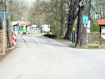 Die Einfahrt zum Zeltplatz, links gibt es einige Parkpl&auml;tze, nach der Schranke sieht man das Geb&auml;ude mit der Rezeption.