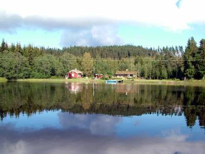 An einer Verbreiterung des Kanals steht mitten im Wald ein Wochenendhaus.